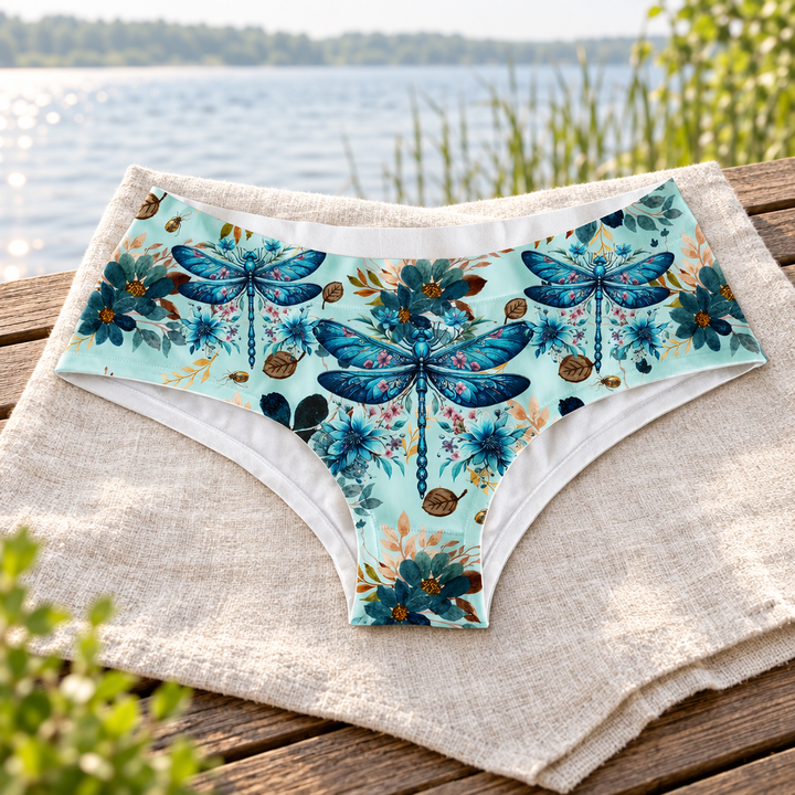 AI-generated styled image of Dragonfly Hipster on linen beside a lake